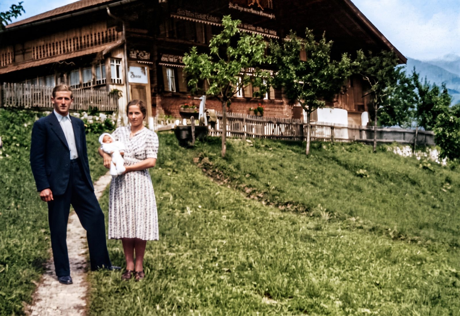 Hans et Rösi Trachsel devant un chalet bernois, leur premier enfant dans les bras